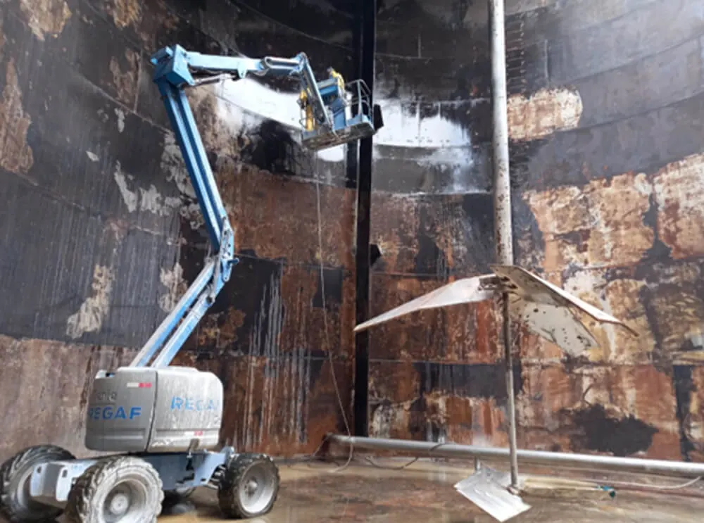 Limpeza da parede interna de um tanque com plataforma elevatória